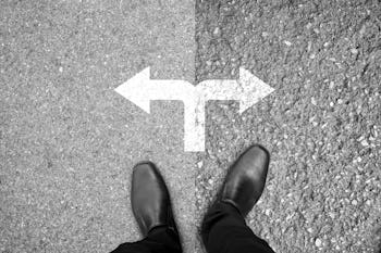 Businessman in black shoes standing at the crossroad making decision which way to go - easy or hard