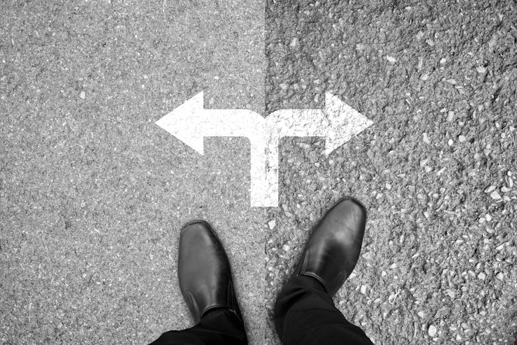 Businessman in black shoes standing at the crossroad making decision which way to go - easy or hard