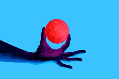 Isolated on blue background photo of man holding moon shape illuminated sphere. Surrealistic collage...