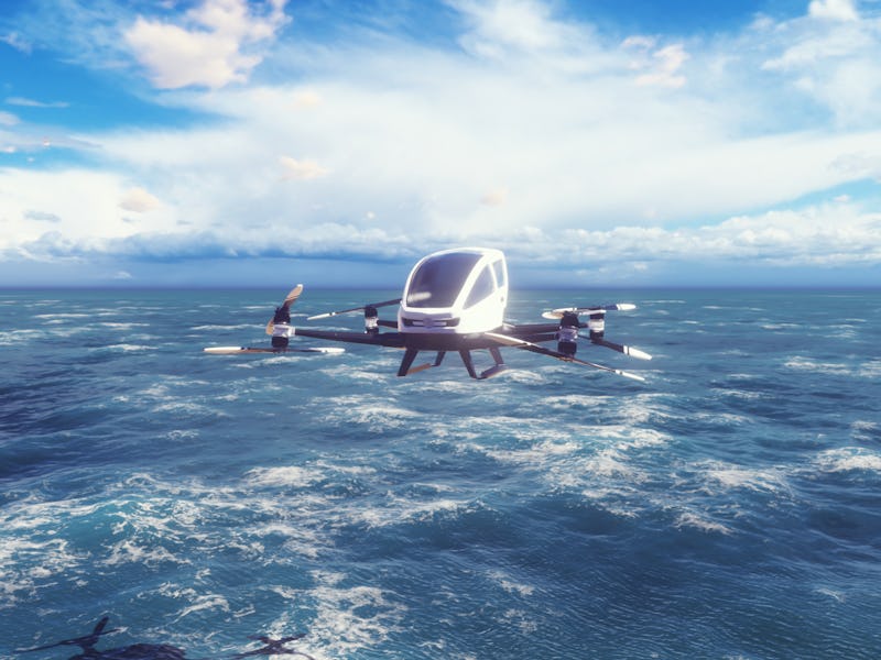An unmanned passenger air taxi flies over the sea. The concept of the future driverless taxi. 3D Ren...