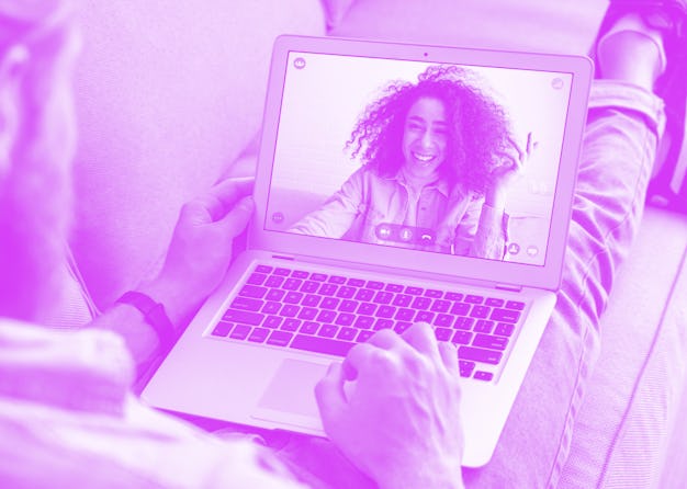 Young caucasian man sit on sofa video calling remote friend african woman talking in online webcam c...