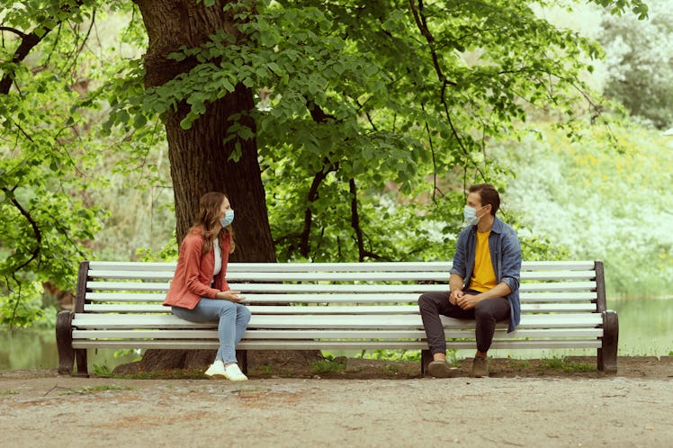 Young, happy, loving couple having date in the park during the coronavirus lockdown crisis. Relation...