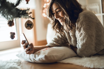 Woman using a smartphone at home - Winter and Christmas Season