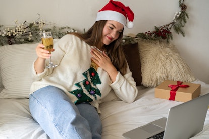 A beautiful girl meets Christmas (New Year) through a video call with friends. Quarantine. Self-isol...