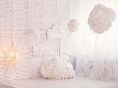 A room is decked out in fluffy clouds, fairy lights, and stars for a dreamy interior that looks like...