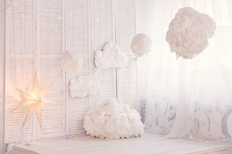 A room is decked out in fluffy clouds, fairy lights, and stars for a dreamy interior that looks like...