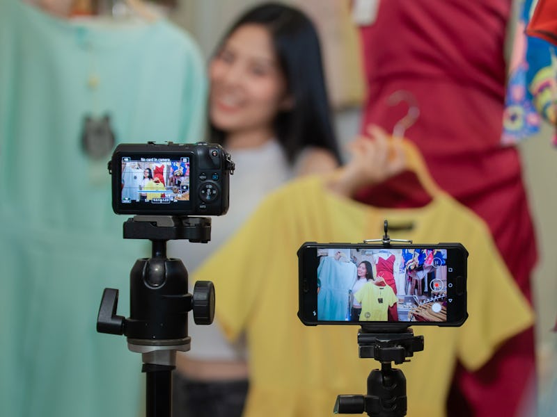 Young Asia girl selling clothes online by live streaming. selling it online live streaming Concept
