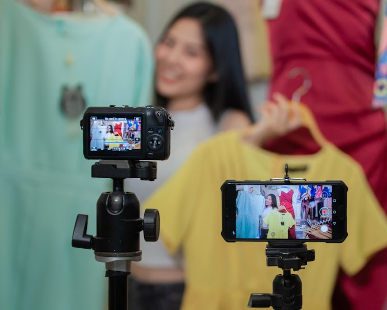 Young Asia girl selling clothes online by live streaming. selling it online live streaming Concept