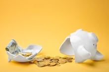 Broken piggy bank with money on color background