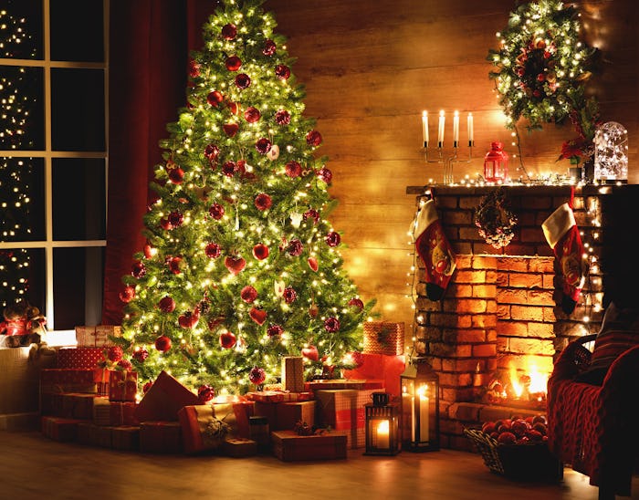 interior christmas. magic glowing tree, fireplace, gifts in dark at night