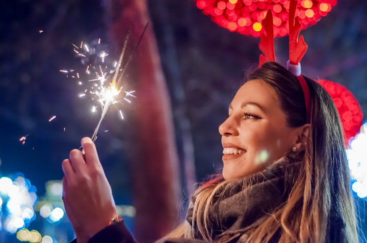 Woman holding bengal lights over bokeh background. Christmas concept.
 Close-up of a beautiful woman...