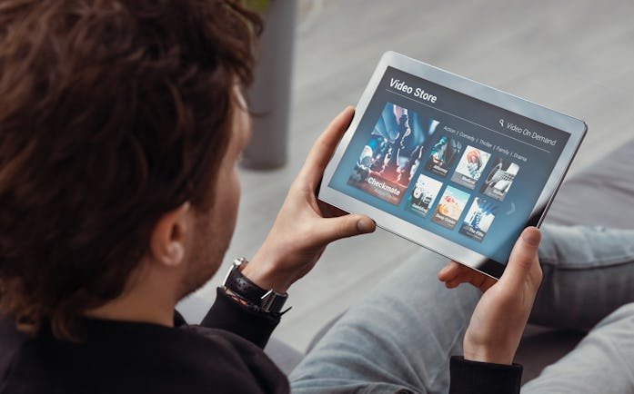 A man can be seen viewing a screen of streaming services.