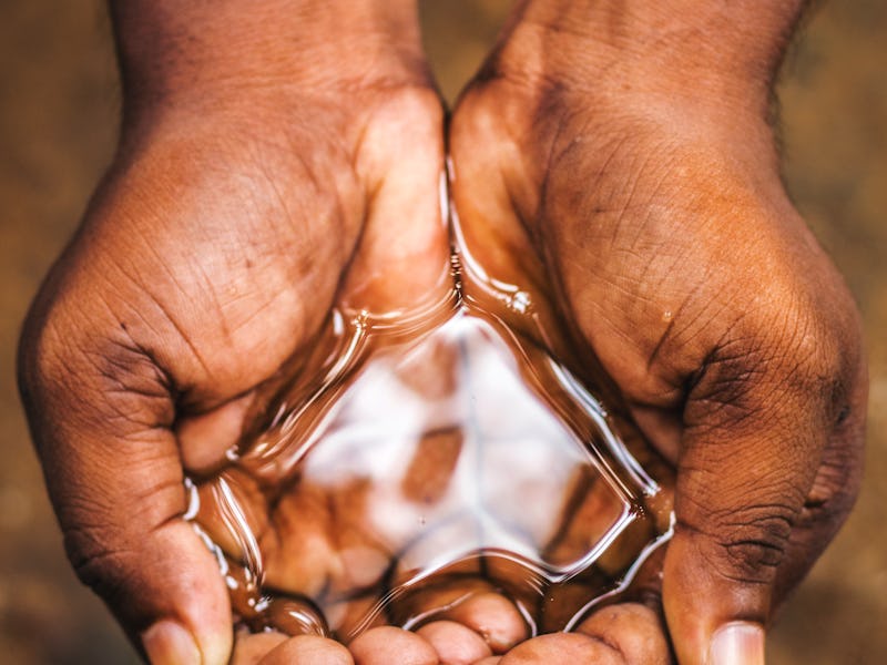 a man holding water with his hand,water crisis in India and worldwide