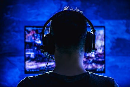 Men wearing headphones playing video games late at night