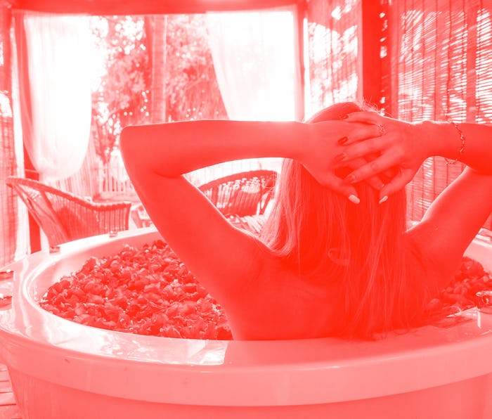 wedding night.beautiful bride and handsome groom relaxing in bath tropical flowers at luxury hotel r...