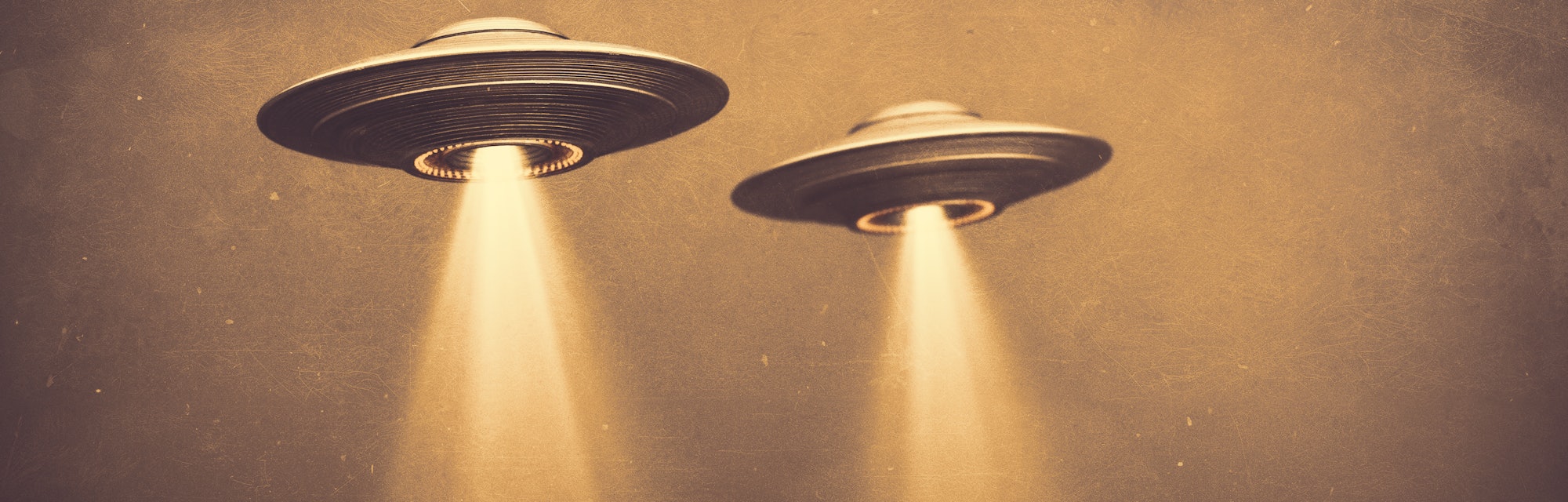 Two UFOs flying in fog with light below. 3D illustration monochromatic sepia-toned old-time photogra...