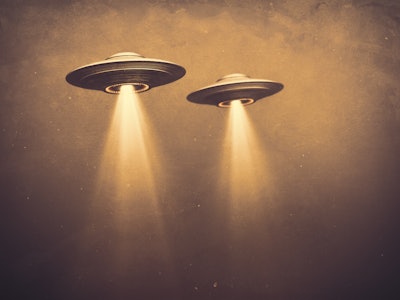 Two UFOs flying in fog with light below. 3D illustration monochromatic sepia-toned old-time photogra...