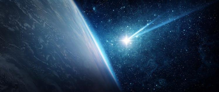 A glowing comet flying to the planet Earth from outer space