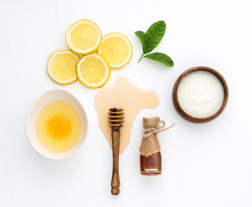 Top view of egg,yogurt,honey and lemon on white background in concept simple homemade hair mask.Natu...