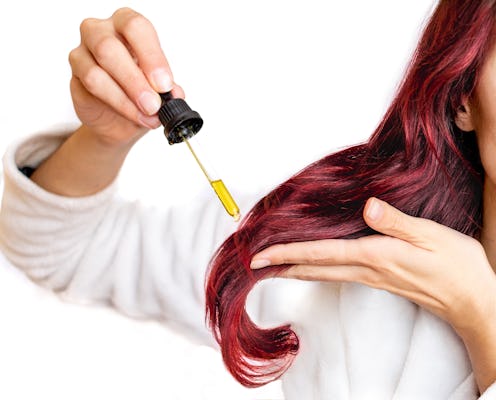 Woman putting oil in her hair.