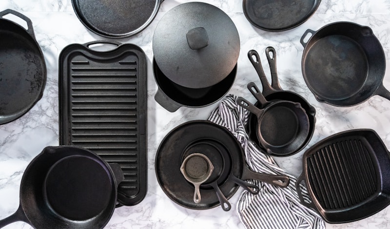 Flat lay. Variety of cast iron frying pans on a marble background.