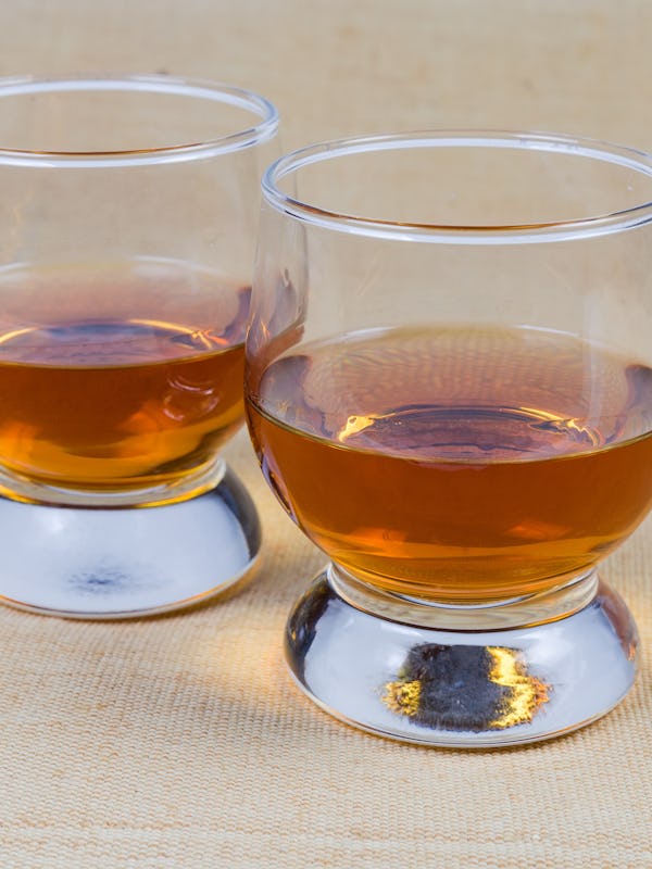 Two portions of brandy in brandy bowls on the tablecloth close-up