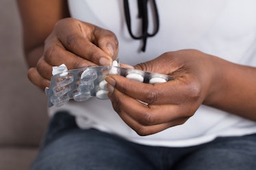 Close-up Of A Human Hand Taking Out Pill From Blister Pack