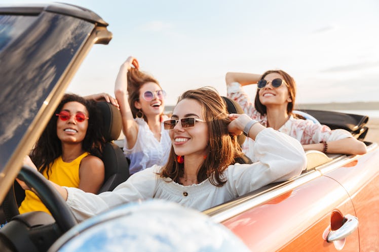 Photo of a beautiful gorgeous smiling cheery young pretty women friends driving the car.