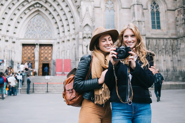 A happy couple stands nears a church in Barcelona, Spain and takes a picture while on spring break.