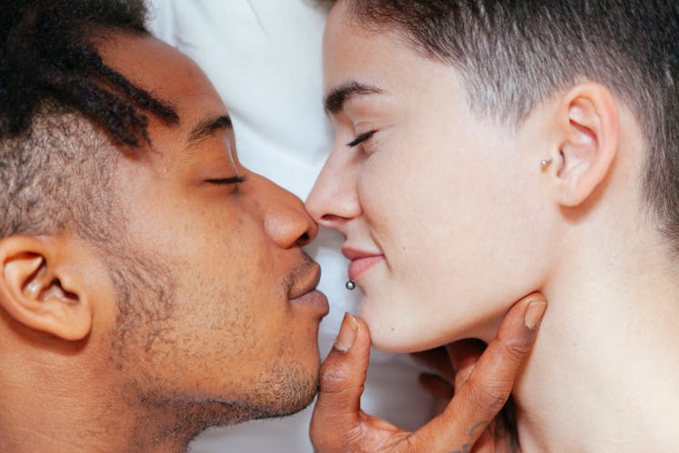Mixed race couple having an intimate moment on the bedroom. lifestyle at home. Young people.