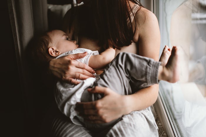 authentic candid woman mom breastfeeds toddler baby, brown toning and lifestyle and dark style, soft...