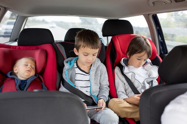 Three children, boys, siblings, traveling in car seats, going on holday