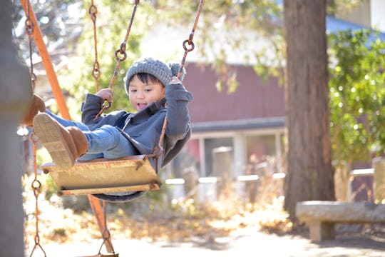 Kid on a swing in a winter park