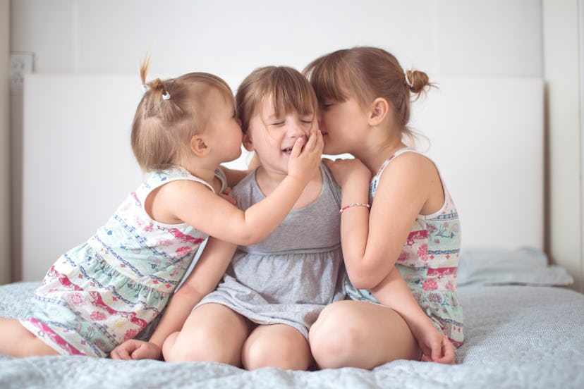 Three sibling sisters on a light background in a real interior. Concept relationships and lifestyle