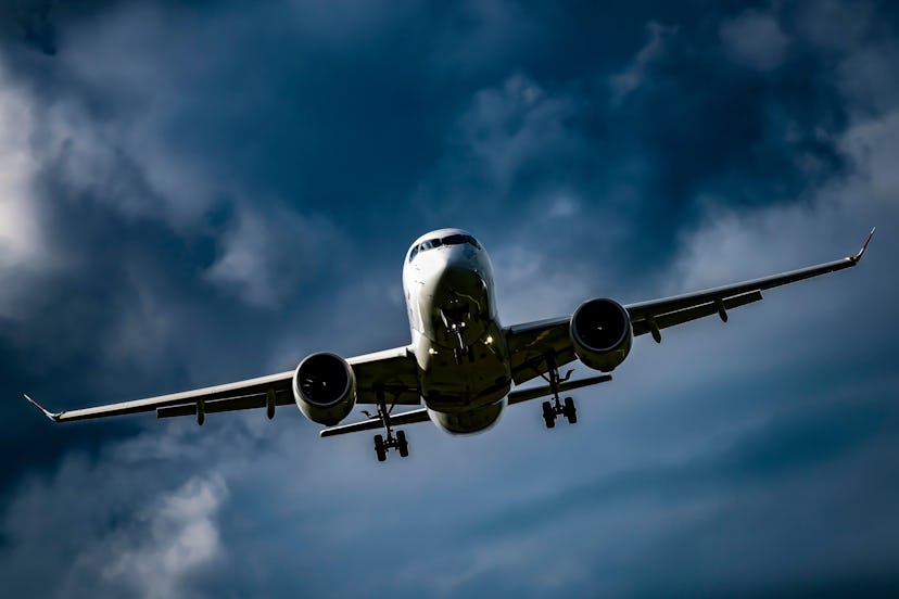 Passenger aircraft Swiss Bombardier CS100 landing approach, dark cloudy sky, Switzerland