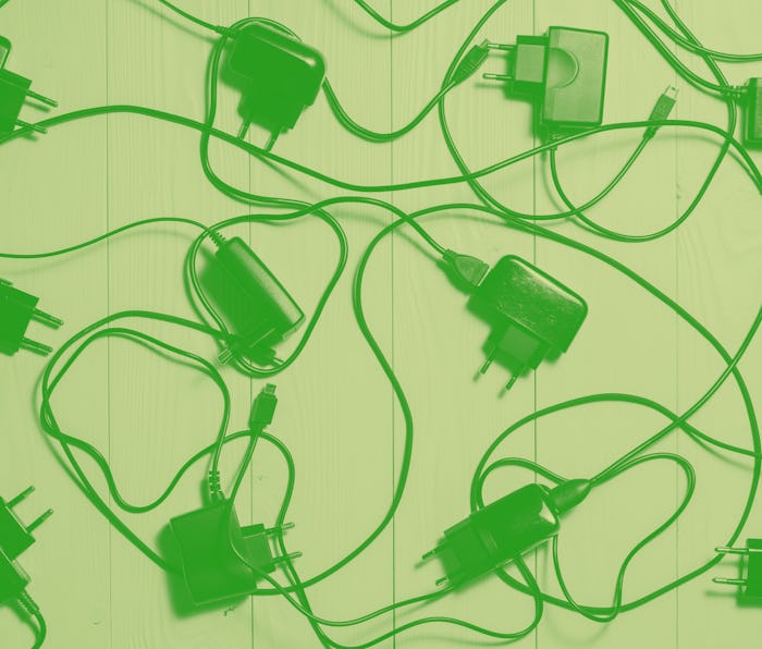 Background of the phone chargers. Used chargers for mobile phones on the wooden background, flat lay...