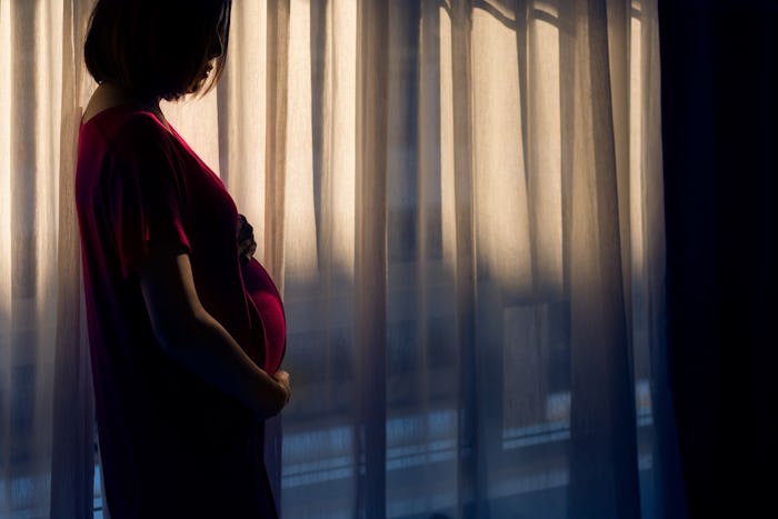 a pregnant woman standing in front of a window, how to handle a breakup when pregnant