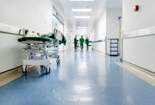 Doctors and nurses walking in hospital hallway, blurred motion.