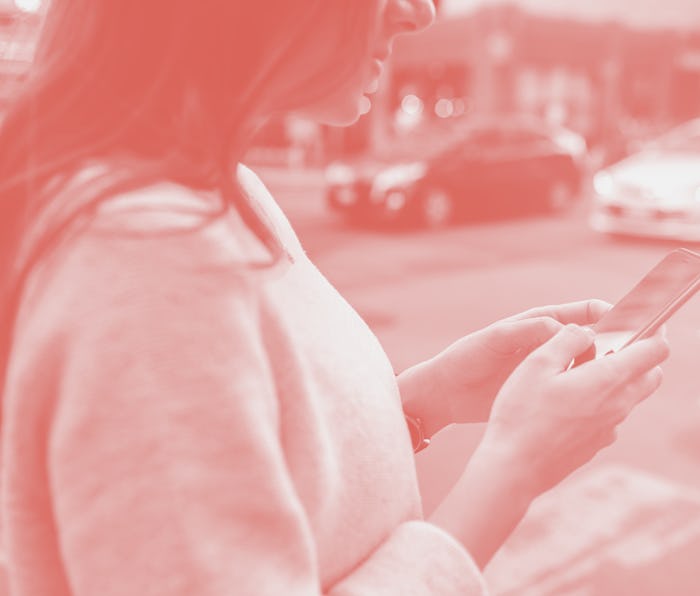 Close-up on woman hands holding smartphone in the center of the city.