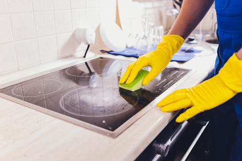 Cleaning kitchen hob with a steam cleaner.