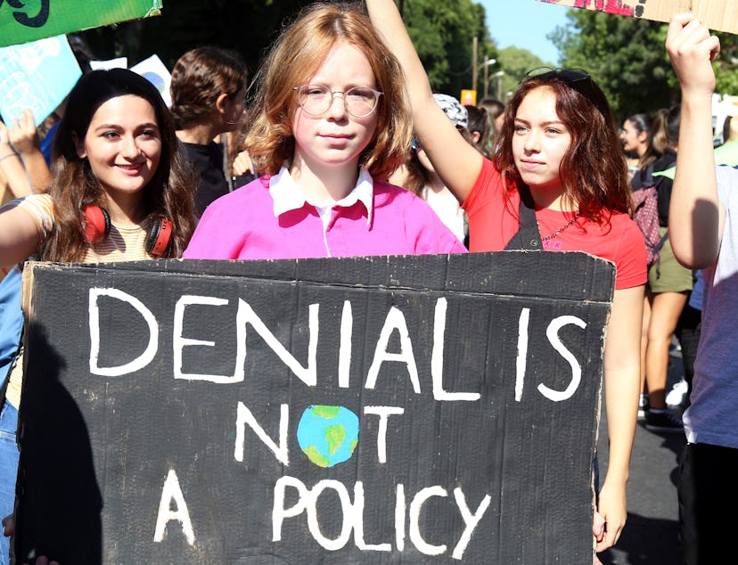 Students with a banner 'Denial is not a policy' gather for a protest against climate change in Nicos...