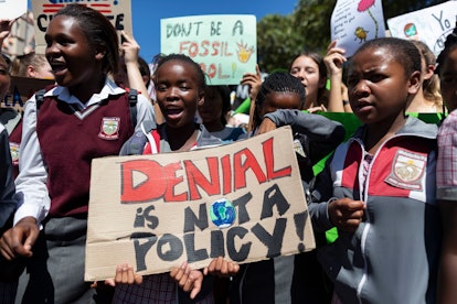 South African youths with a placard 'Denial is NOT a Policy' take part in the Global Strike for Clim...