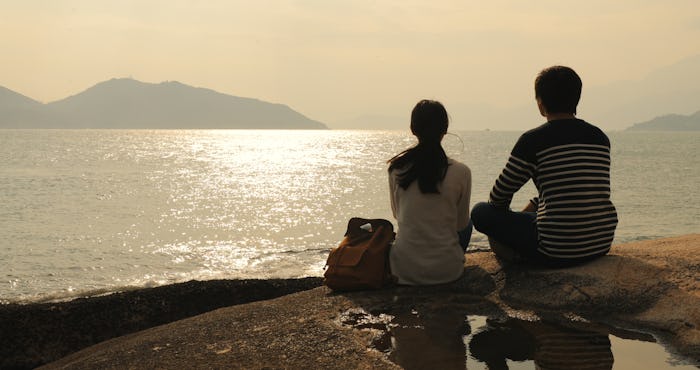 Couple enjoy the view of seascape under sunset