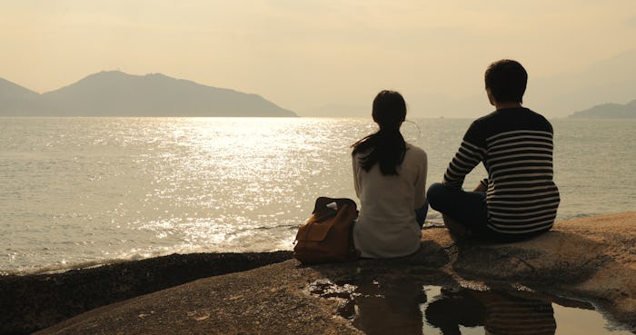 Couple enjoy the view of seascape under sunset 