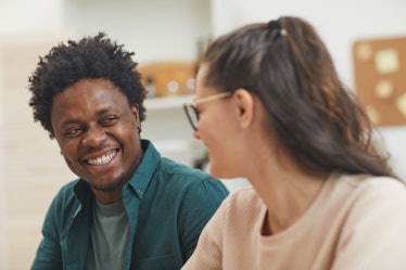 Happy multiethnic young couple talking to each other and spending funny time together