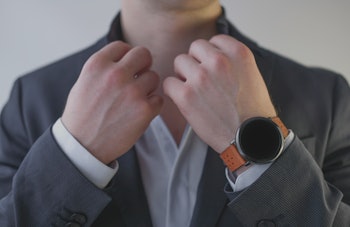 Man in a suit with a wrist watch.