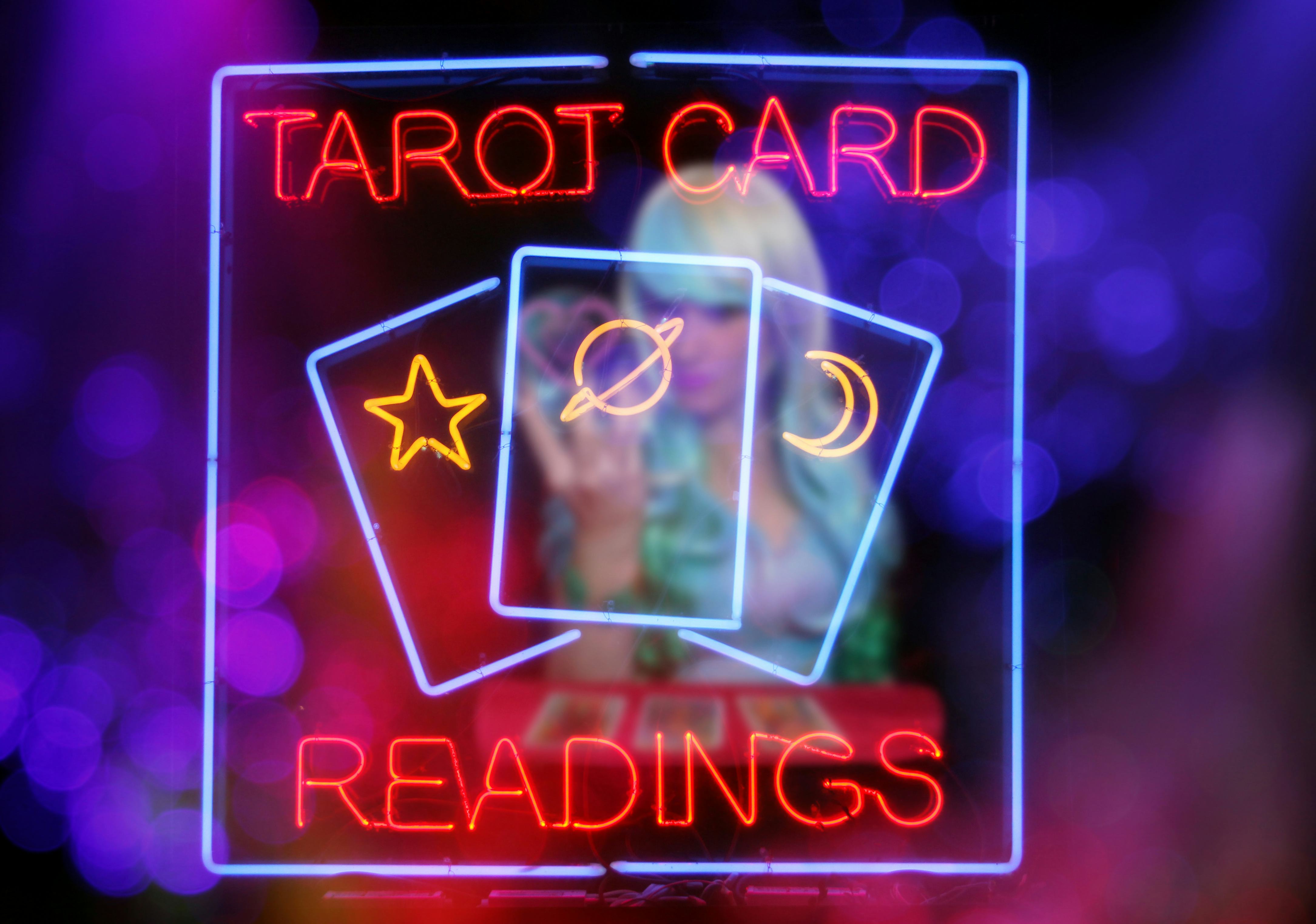 Tarot Card Readings Neon Sign in Window with Psychic Tarot Card Reader blurred in background