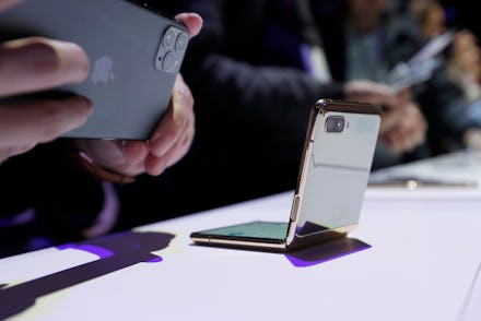 A media member photographs the new Galaxy Z Flip smartphone with his Apple iPhone 11 Pro during the ...