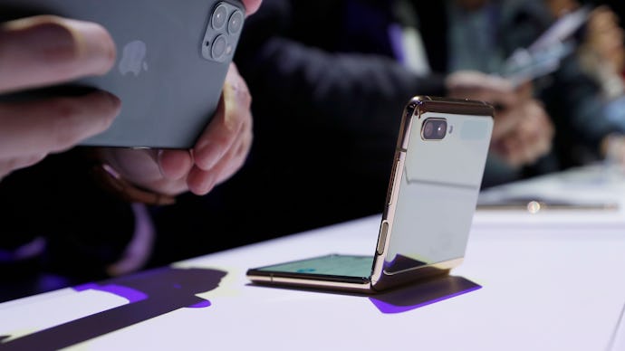 A media member photographs the new Galaxy Z Flip smartphone with his Apple iPhone 11 Pro during the ...