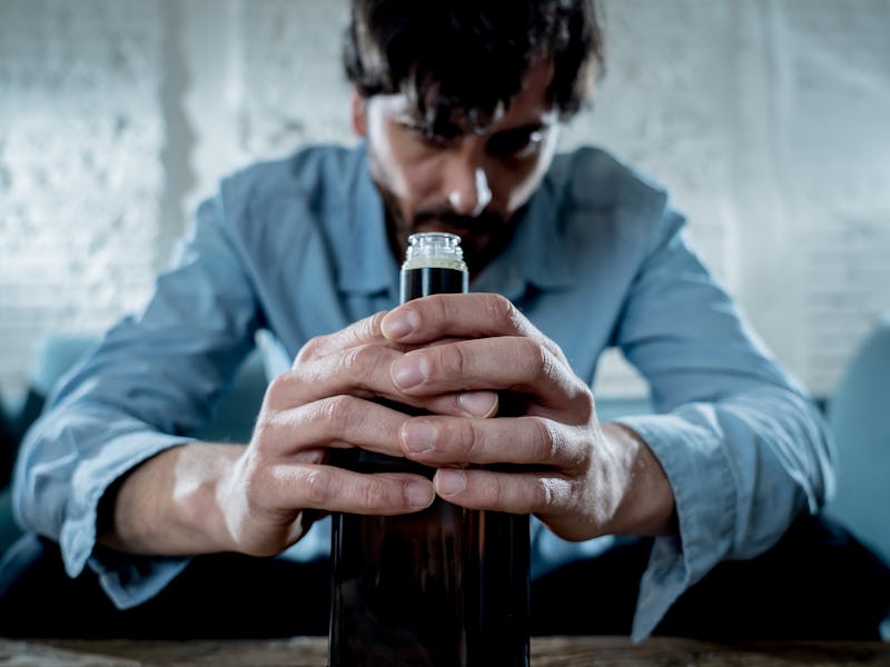 drunk alcoholic lain business man drinking whiskey from the bottle and glass depressed wasted and sa...